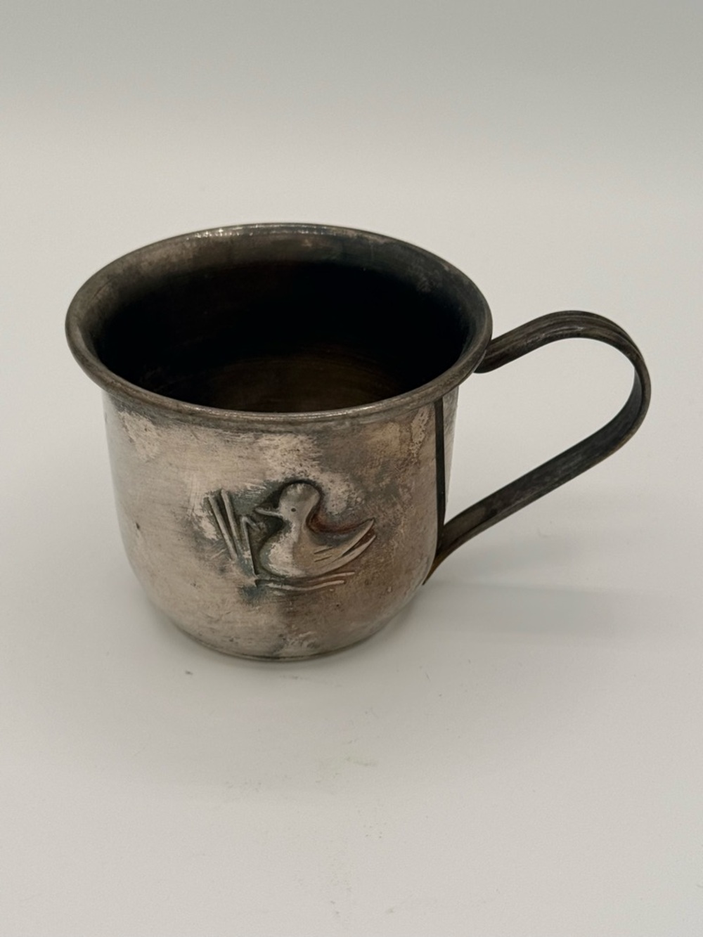 Vintage silver-plated child's cup with embossed duckling motif.